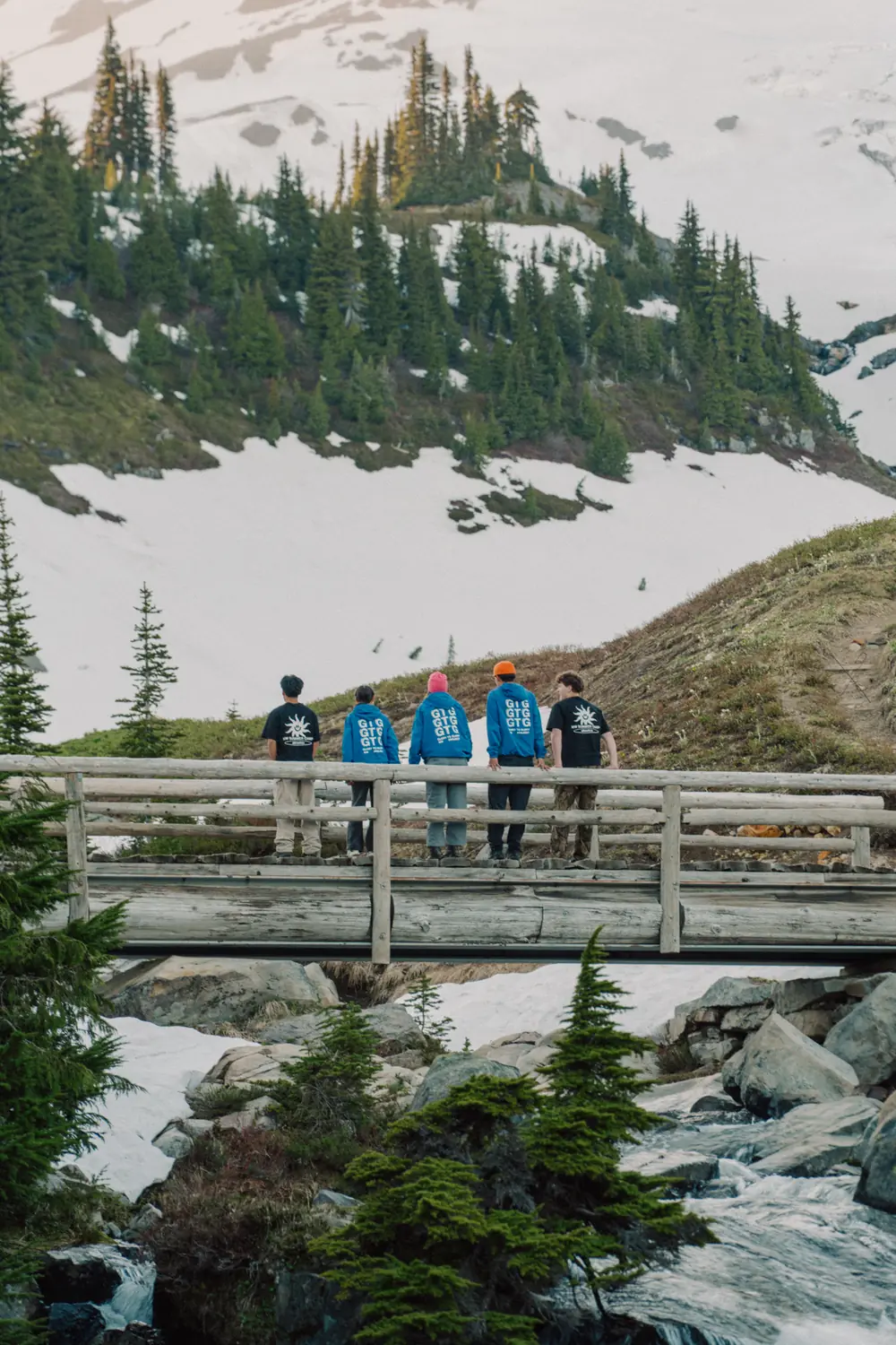 Campers in Summer Camp 2026 gear on a bridge outdoors